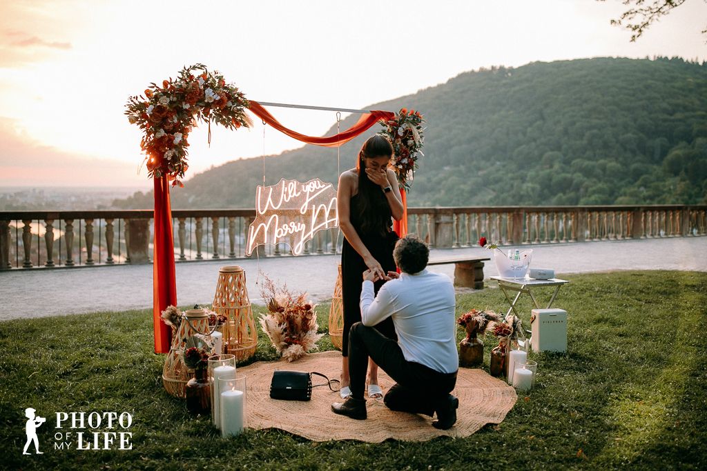 Boho Love marriage proposal decoration – kneeling at sunset with romantic flower arrangement
