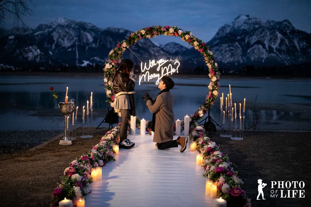 Flower Magic proposal decoration at alpine lake – white flower arch with candle path