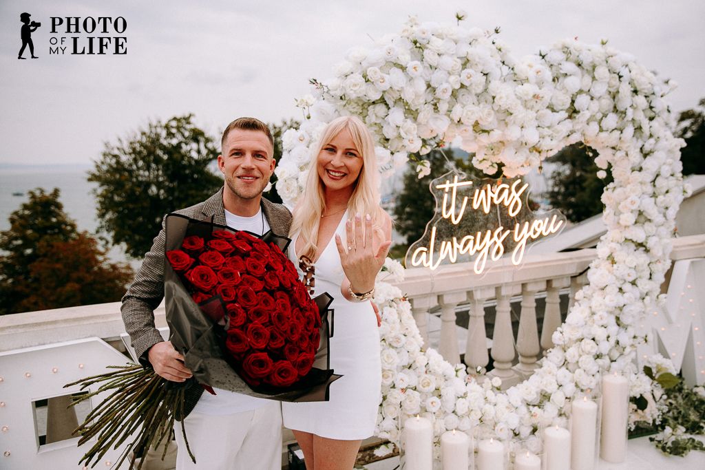 Heaven on Earth proposal – white heart decoration with couple and romantic lake view