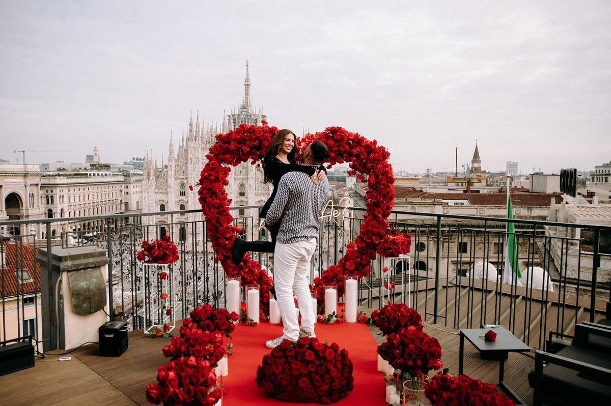 Marriage proposal in Milan – rooftop near the Duomo with red heart, man kneeling