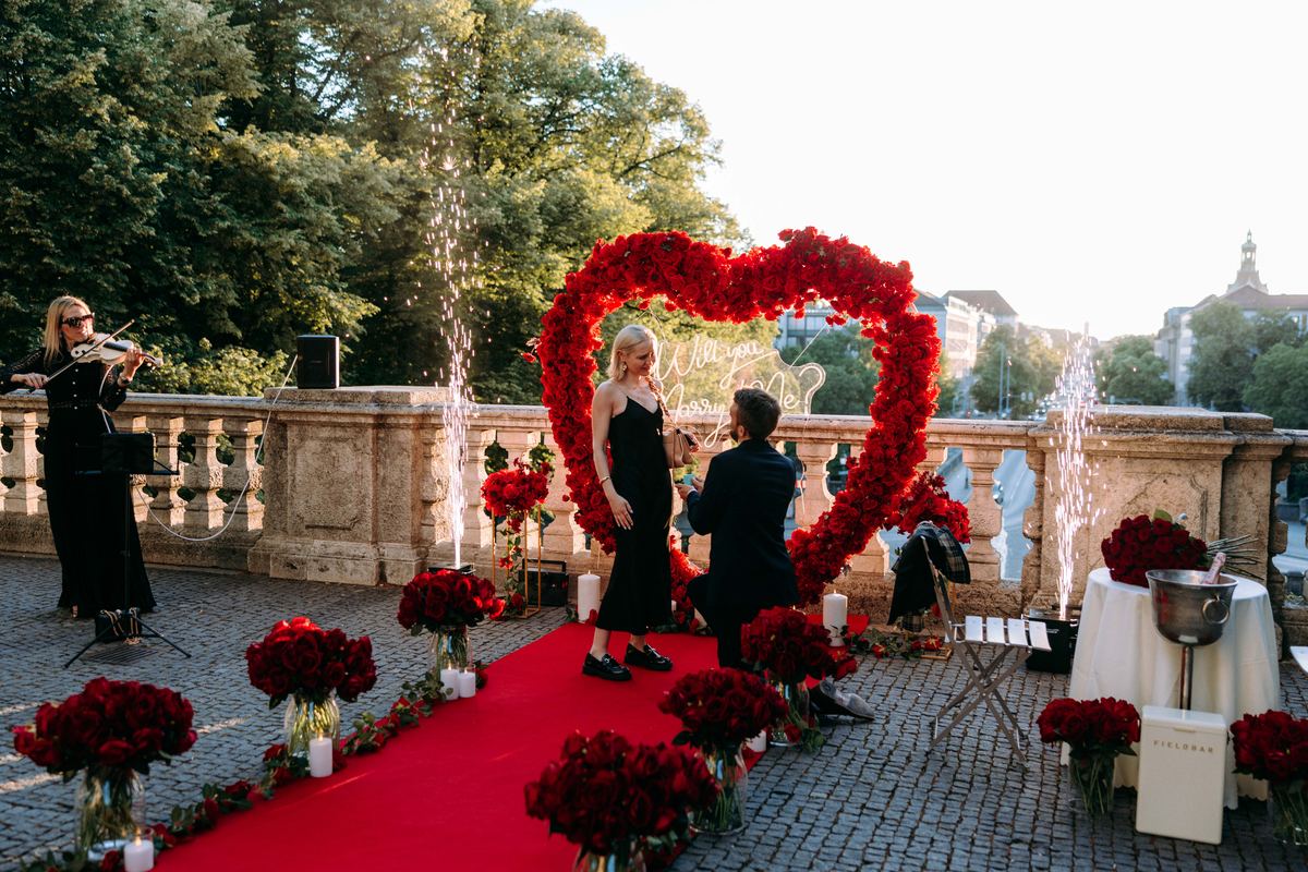 Marriage proposal in Munich – bridge with red heart, live violinist and fireworks display