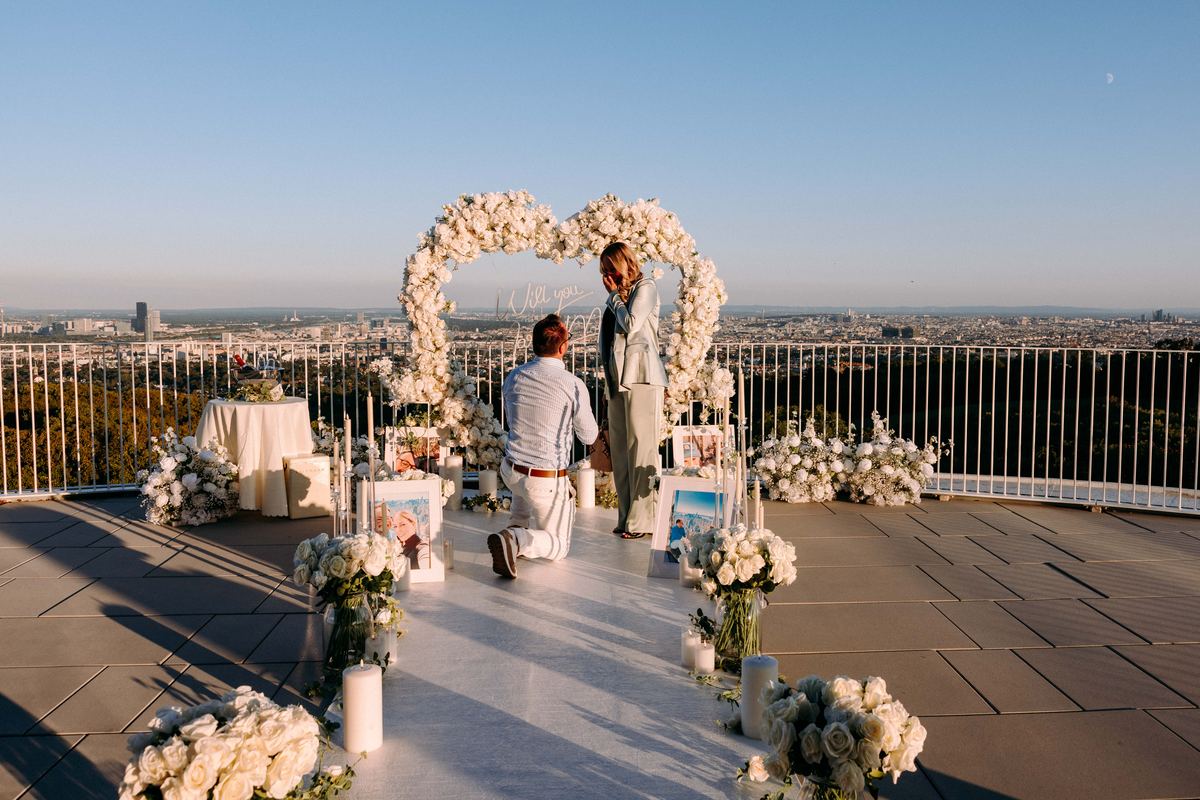 Marriage proposal in Vienna – rooftop with white heart, city panorama at golden sunset