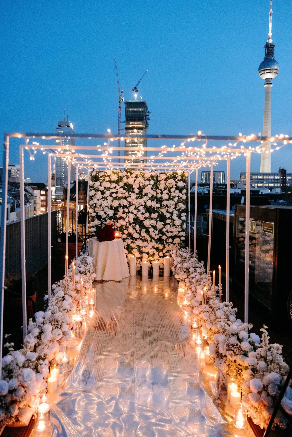 Shine Bright proposal in Berlin – TV Tower view with fairy lights tunnel and white flower wall