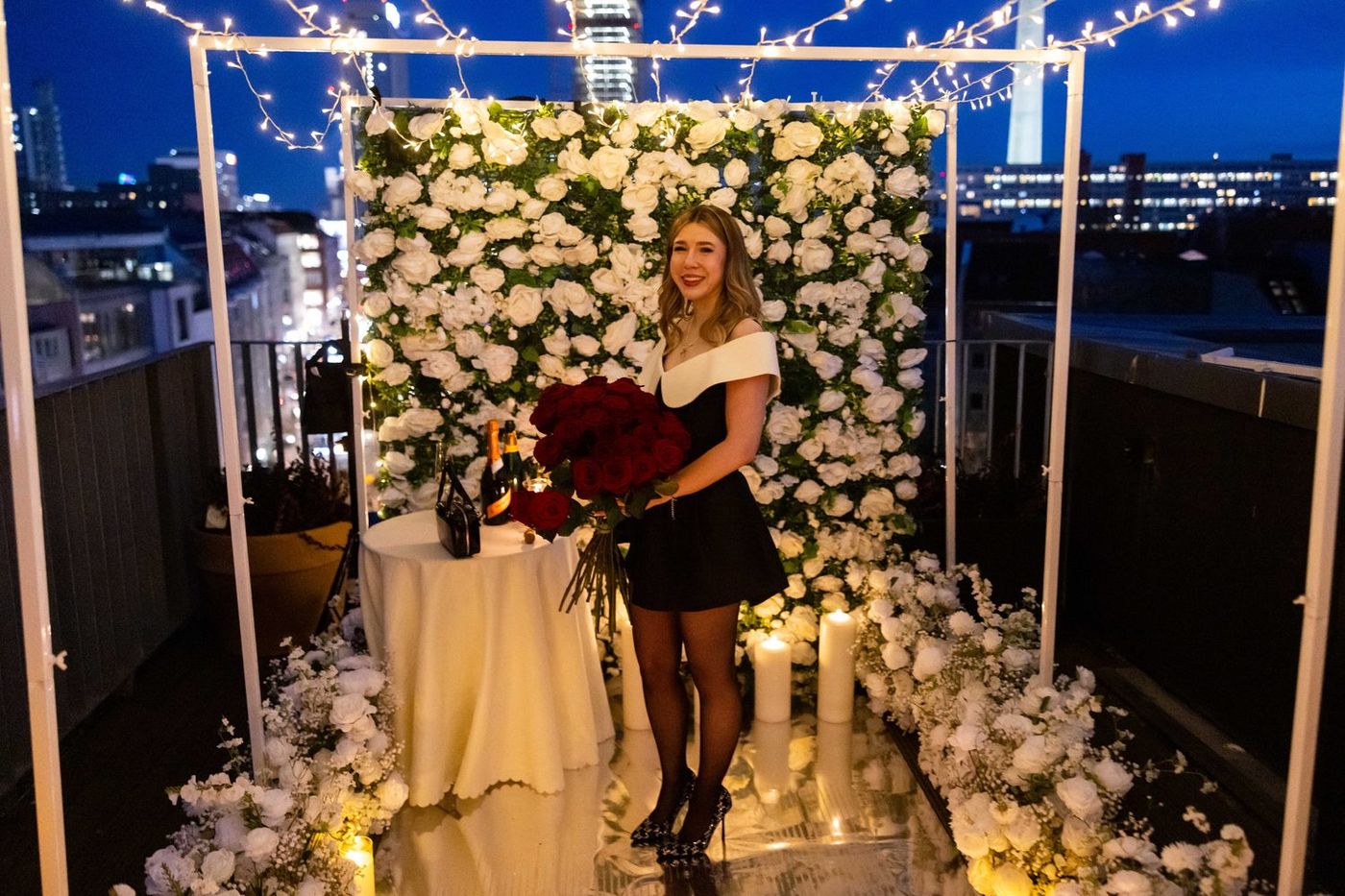 Shine Bright proposal in London at night – white rose flower wall with romantic candle path
