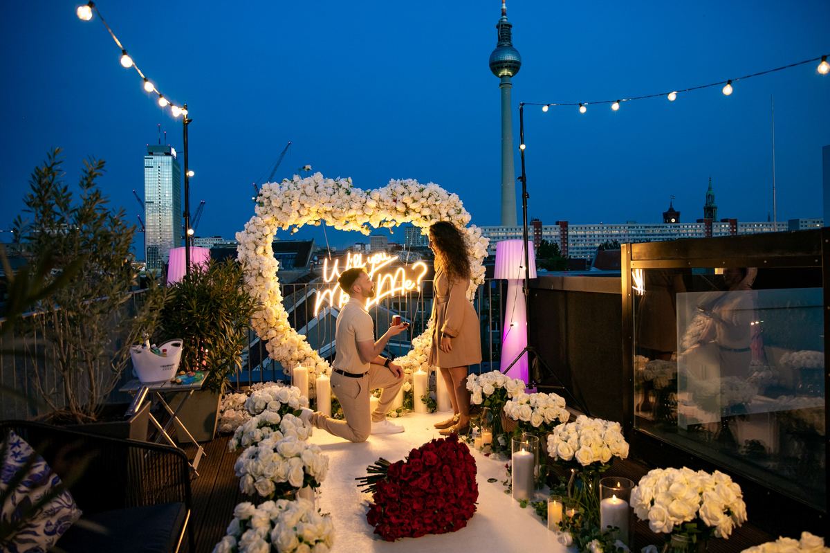 Marriage proposal in Berlin – TV Tower rooftop, white heart with man kneeling at night