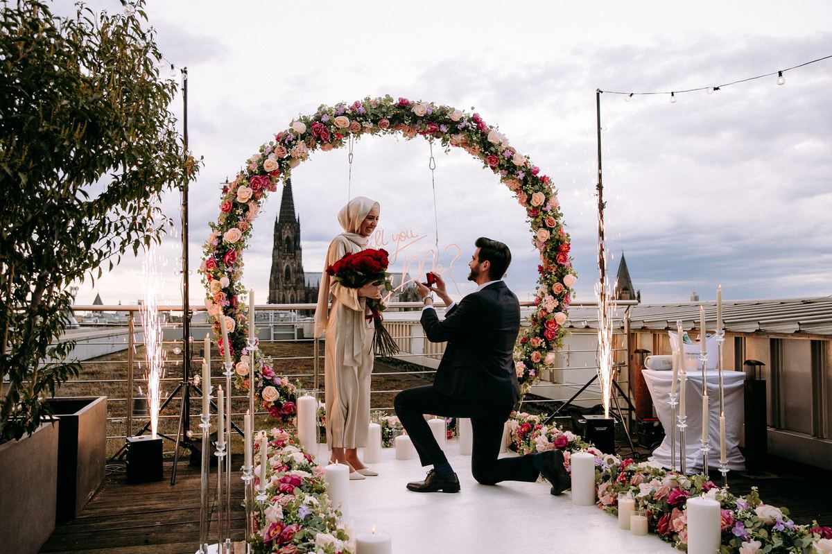 Marriage proposal in Cologne – cathedral rooftop with white flower arch and fireworks