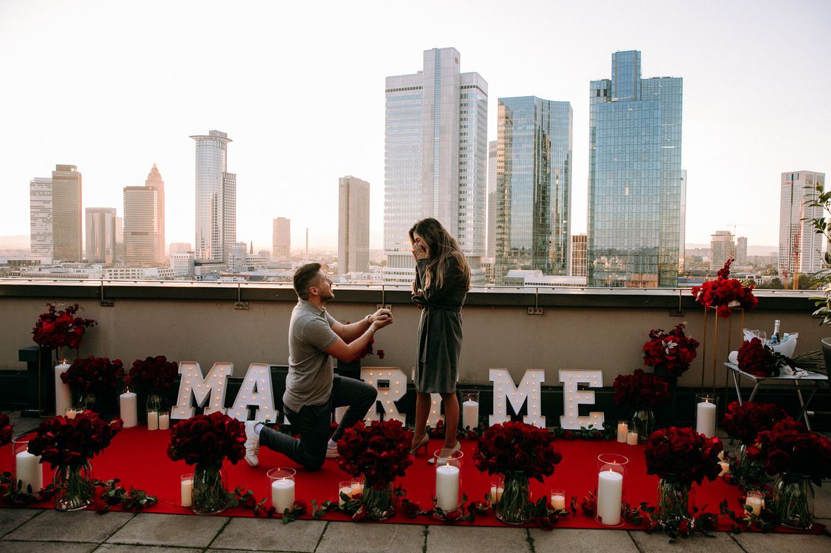 Marriage proposal in Frankfurt – skyline rooftop with man kneeling at golden sunset