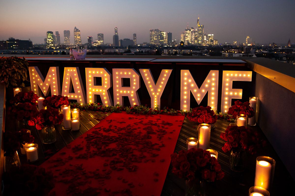 Marriage proposal in Frankfurt – skyline rooftop with MARRY ME letters at night