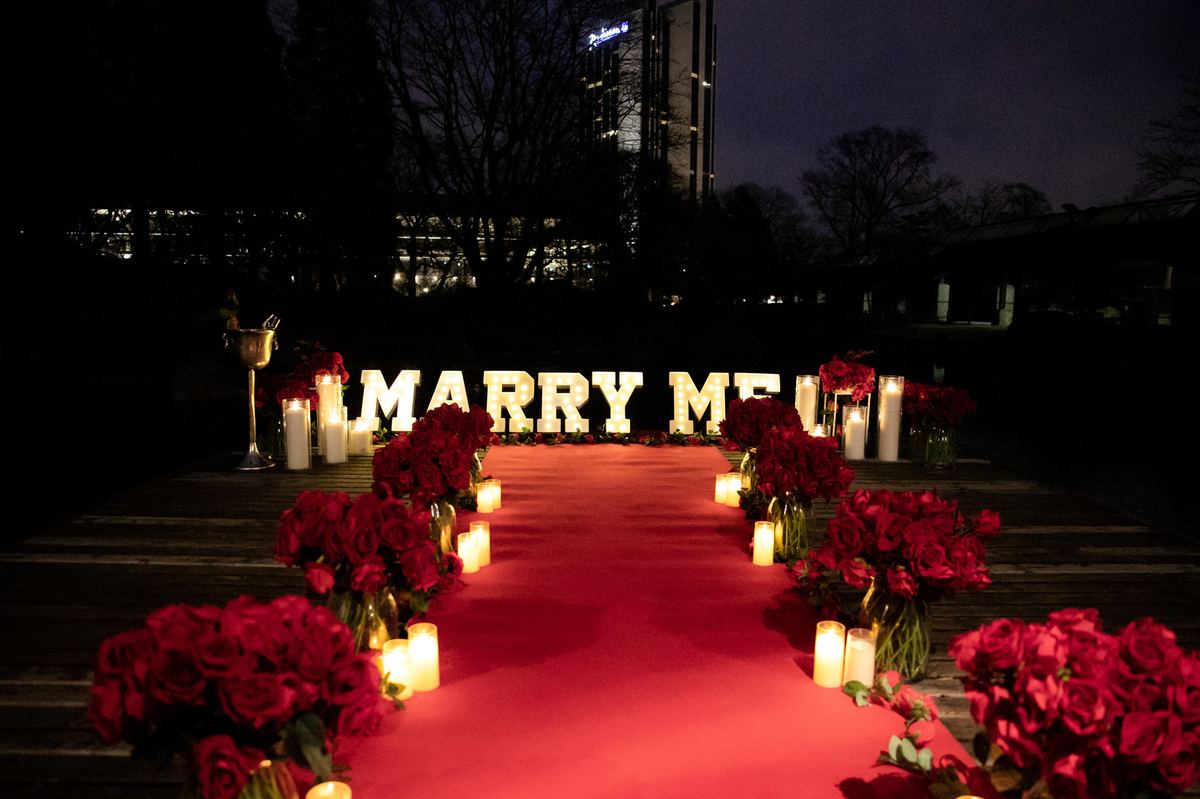 Marriage proposal in Hamburg park – MARRY ME letters with red roses at night