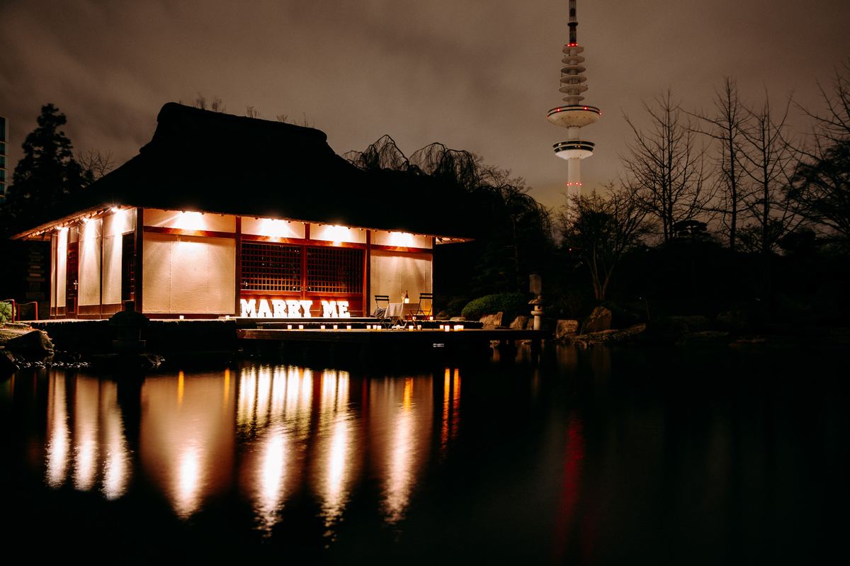 Marriage proposal in Hamburg Planten un Blomen – tea pavilion with MARRY ME at night